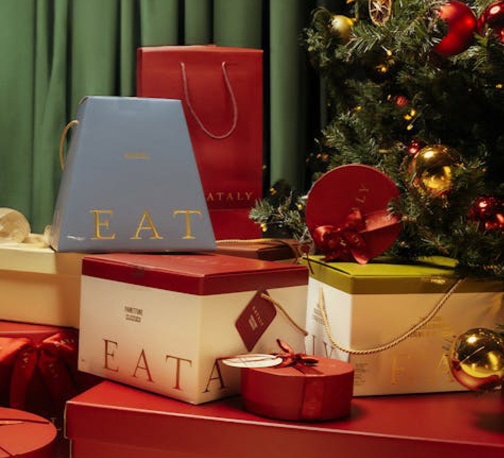 Coffrets et paniers cadeaux Eataly devant un sapin de Noël